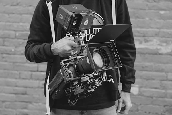team member with handheld camera black and white