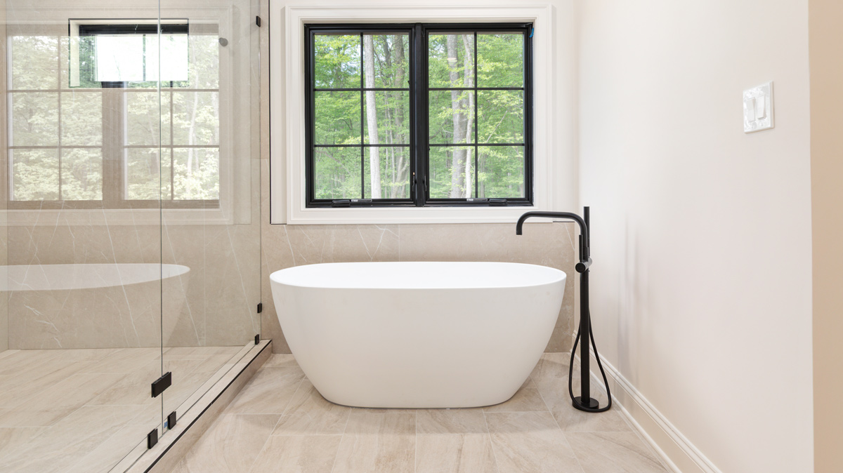 soaking tub with large windows overlooking woods