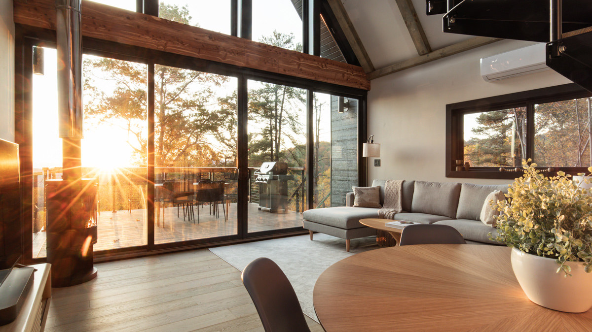 living room wall of windows overlooking balcony at sunset