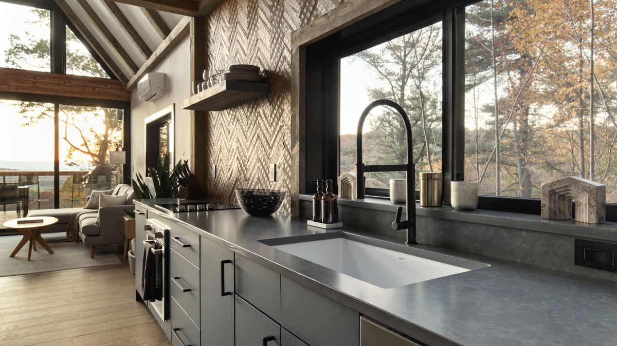 kitchen view of sink and countertops with the living room in the background