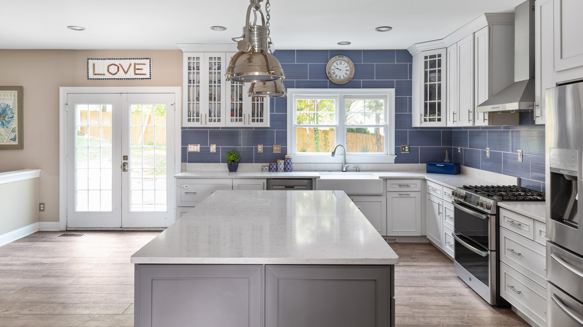 slate blue kitchen with island and french doors leading to the back yard