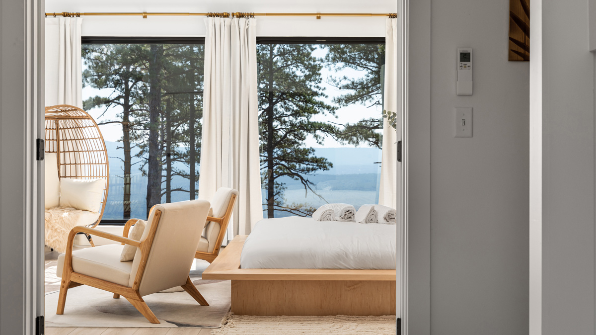 master bedroom with large windows overlooking the mountains and lake