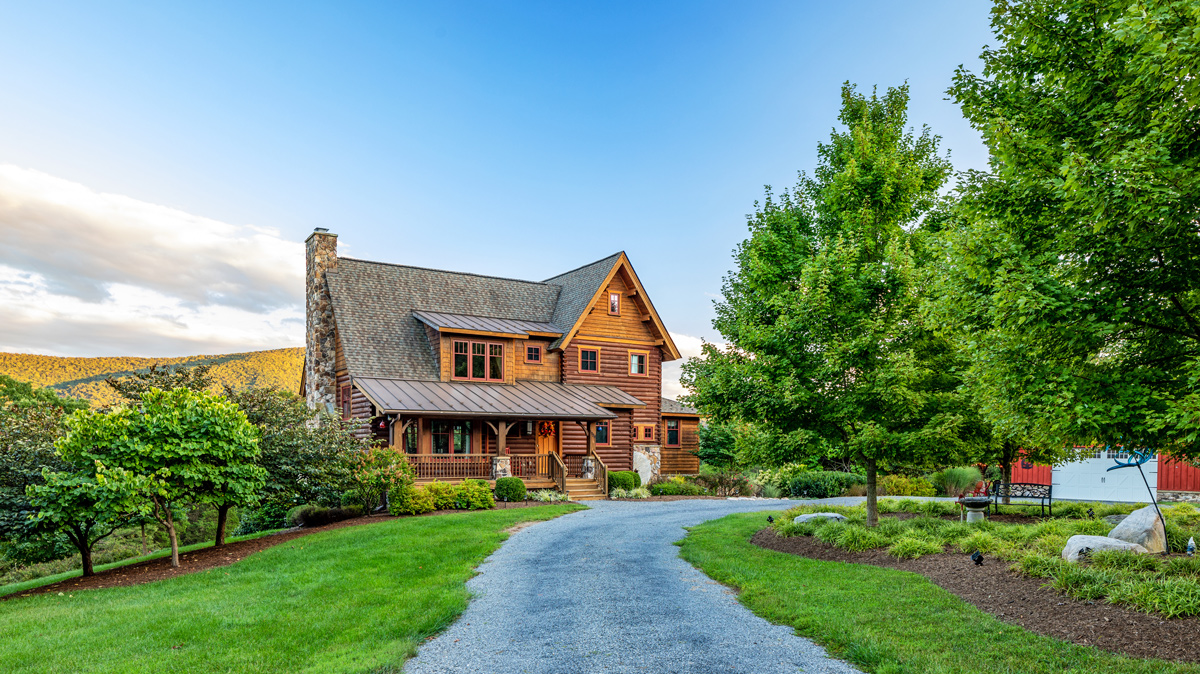 driveway view of a two story cabin overlooking the mountains
