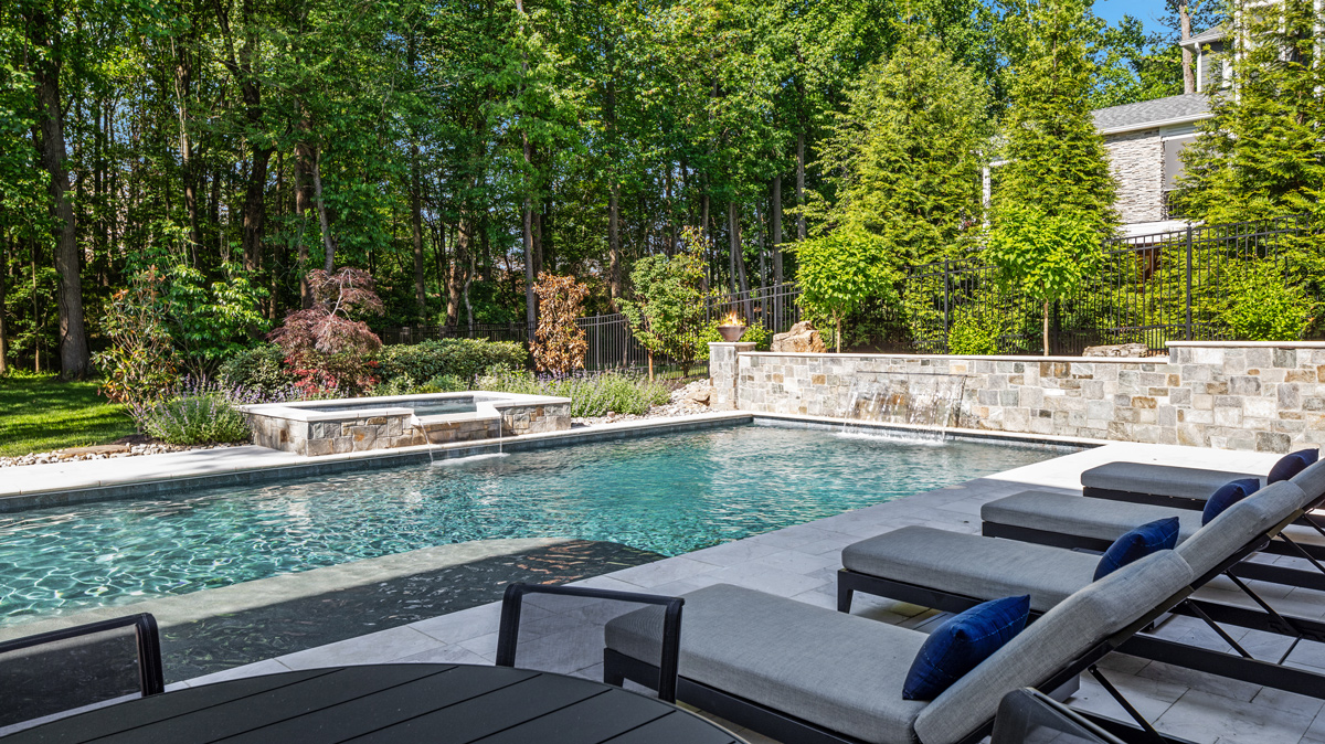view of in-ground pool and hot tub from lounge chairs