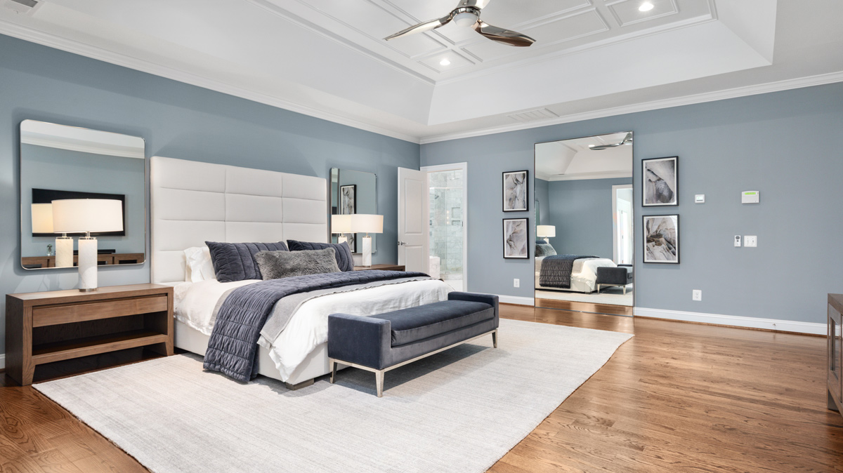 powder blue master bedroom with wood flooring and high ceilings, includes ensuite
