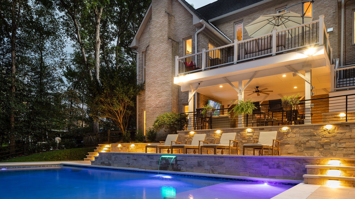 back patio and pool area featuring lounge chairs, balcony, and outdoor living room area